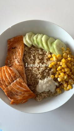 a white plate topped with salmon, rice and corn