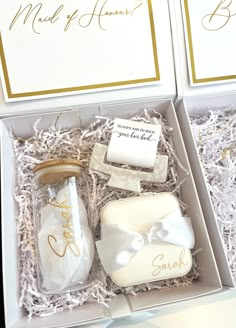 two white boxes with gold lettering on them, one is open and the other has a bottle in it