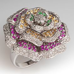 This beautiful ring feature a floral design, shared prong set with a total of one hundred thirty-seven (137) round brilliant cut diamonds, fifty-nine (59) round brilliant cut pink sapphires, forty-one (41) round brilliant cut yellow sapphires and eight (8) round brilliant cut tsavorite garnets. The ring measures 29.2mm at the top, rises 14.6mm above the finger, tapering to 2.7mm wide and 1.0mm thick at the base of the shank. It is currently a size 7.25. Elegant Multicolor Ruby Ring With Diamond Setting, Elegant Multicolor Ruby Ring With Diamonds, Luxury Pink Diamond Flower Ring, Zipper Jewelry, 1st Dibs, Floral Cocktails, Treasure Jewelry, Tsavorite Garnet, Yellow Sapphire