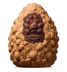 an egg shaped like a lion head with shells around it's body and eyes