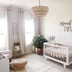 a baby's room with a white crib, rug and chandelier