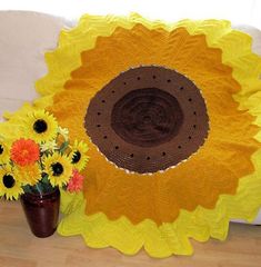 a sunflower is sitting on the floor next to a vase with flowers in it