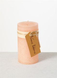 a pink candle with a tag on it