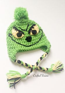 a crocheted green hat with black eyes