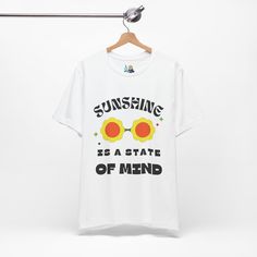 Brighten up your wardrobe with the 'Sunshine State of Mind' Unisex Tee, exuding hippie vibes and positive energy. Featuring a playful graphic of retro flower sunglasses, this tee spreads good vibes and reminds you that sunshine is a state of mind. Crafted from 100% Airlume combed and ring-spun cotton, this tee offers a lightweight and breathable fabric perfect for both active and leisure wear. The classic crew neckline and ribbed knit collars provide a timeless look, while the tapered shoulders Retro Summer T-shirt With Slogan, Retro Printed Summer T-shirt, Fun Slogan T-shirt For Spring, Summer Music Festival Tops With Text Print, Spring Music Festival Relaxed Fit T-shirt, Relaxed Fit T-shirt For Spring Music Festival, Retro Text Print T-shirt For Summer, Retro Slogan T-shirt For Spring, Hippie Cotton T-shirt For Summer