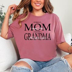 Celebrate the special women in your life with our personalized First Mom Now Nana Mothers Day shirt.  This beautiful shirt features a unique script heart design with the names of your choice, making it a thoughtful and heartfelt gift for any proud auntie, grandma, nana, or mom. This shirt is not only a beautiful and sentimental gift, but it's also a one-of-a-kind keepsake that the recipient will cherish for years to come. It's perfect for Mother's Day, birthdays, or just because! Order now and s Mother's Day Short Sleeve Shirt With Custom Print, Pink Tops With Text Print For Mother's Day, Mother's Day Crew Neck Shirt With Text Print, Mother's Day Text Print Crew Neck Shirt, Mother's Day Letter Print Short Sleeve Tops, Mother's Day Gift Tops With Text Print, Mother's Day Text Print Top, Short Sleeve Tops With Letter Print For Mother's Day, Crew Neck Shirt With Text Print For Mother's Day