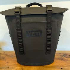 a black yeti cooler bag sitting on top of a wooden table