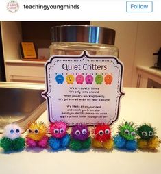 a jar filled with colorful pom poms sitting on top of a counter