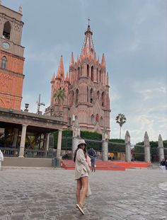 a woman is walking in front of an old building