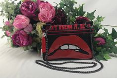 a red and black purse with the words don't dream it be on it