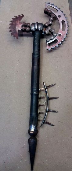 a large metal tool with spikes attached to it's handle and two other tools on the ground