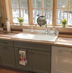 a kitchen sink sitting under a window next to a dishwasher