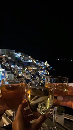 several people toasting with wine glasses in front of a cityscape at night