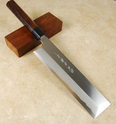 a large knife with a wooden handle sitting on top of a counter