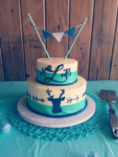 a three layer cake decorated with blue and white frosting on top of a table