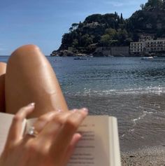 someone is reading a book on the beach