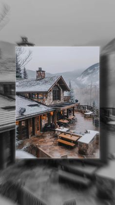 an image of a house in the middle of winter with snow on the ground and mountains behind it