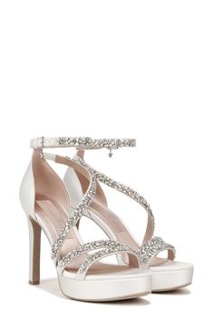 The sandal features dazzling jewels that detail slender satin straps with a subtle platform base and tapered heel. World-renowned bridal designer Pnina Tornai created a dreamy collection with Naturalizer of wedding-ready styles that exude luxurious elegance and are aptly named 'love' in different languages. 3 3/4" heel; 3/4" platform Slip-resistant sole Textile upper and lining/leather sole Imported High Heel Satin Sandals For Wedding, Satin Heels With Rhinestones For Wedding, Glamorous Satin Wedding Heels, Silver Sandals With Heel Strap For Wedding, Crystal-embellished Wedding Shoes With Ankle Strap, White Satin Fabric, Wedding Ready, Pnina Tornai, Different Languages