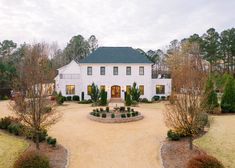 a large white house surrounded by trees and bushes