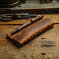 a leather pen case sitting on top of a wooden table