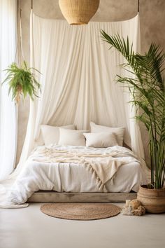 a bed with white sheets, pillows and plants in a room that looks like it has been made into a canopy