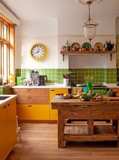 a kitchen with yellow cabinets and green tile backsplash, wooden counter tops, and a large clock on the wall