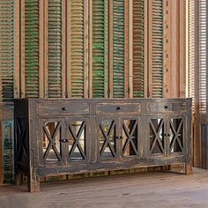 an old wooden bench sitting in front of a wall with shutters on the side