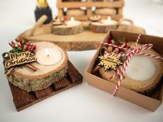 two wooden slices with christmas decorations and candles in them on a white tablecloth background