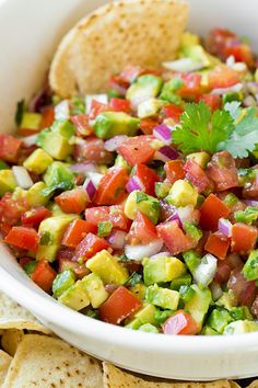 a salad with tomatoes, avocado and other vegetables