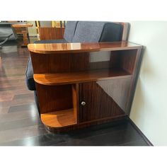 a wooden shelf sitting on top of a hard wood floor next to a gray couch