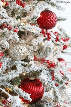 a white christmas tree with red and silver ornaments