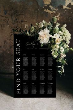 a black and white wedding seating chart with flowers