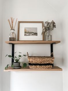 two shelves with plants and vases on them, one has a wicker basket