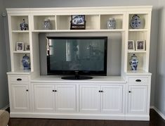 an entertainment center with built in shelves and a flat screen tv