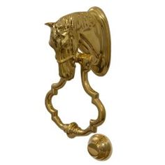 a golden horse head door knockle with a ball in the foreground and a white background