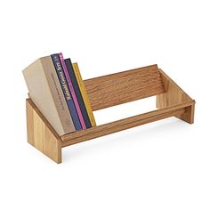 a wooden book stand with books on it's sides and two stacks of books in the middle