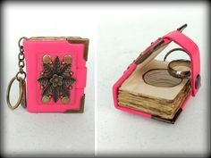 a pink book shaped keychain with a flower design on the front and side