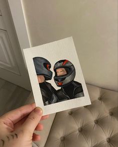 a person holding up a card with an image of two people wearing helmets