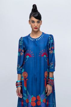 Midnight blue straight kurta with floral print and delicate mirror embroidery. Paired with a pant with patterned patch.
Components: 2
Pattern: Printed, Embroidered
Type Of Work: Floral, Mirror
Neckline: Round
Sleeve Type: Puffed
Fabric: Cotton Silk Blend
Color: Blue
Other Details: 
Approx. product weight: 800 gms
Model Height: 5ft 9inches, wearing size S
Note: Jewellery worn by the model is not for sale.
Occasion: Puja - Aza Fashions Bohemian Blue Set With Floral Embroidery, Bohemian Blue Sets With Floral Embroidery, Bohemian Blue Blouse With Printed Motifs, Blue Bohemian Blouse With Printed Motifs, Summer Indigo Sets With Printed Motifs, Blue Silk Sets For Summer, Fitted Blue Tops With Printed Motifs, Festive Blue Blouse With Floral Print, Blue Festive Tops For Spring