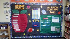 a bulletin board with an apple on it in front of a book shelf filled with books