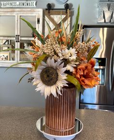 a vase filled with flowers sitting on top of a counter