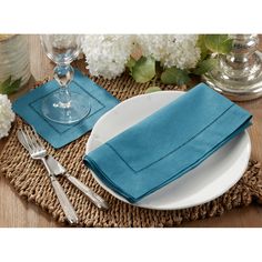 a place setting with blue napkins and silverware