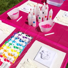 the table is set up with art supplies for children to use on their artwork projects