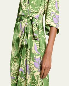 Dries Van Noten "Dakola" wrap midi dress in an allover abstract printed finish     Spread collar    Short sleeves    Selftie closure at hip     Hem hits around the knee    Aline silhouette     Viscose    Made in Poland Viscose Knee-length Midi Dress With Tie Waist, Knee-length Viscose Midi Dress With Tie Waist, Green Abstract Print Midi Dress, Green Printed A-line Midi Dress, Green Midi Dress With Abstract Print, Green Midi Length Dress With Abstract Print, Green Midi Dress With Tie Waist And Surplice Neckline, Green Surplice Neckline Dress With Tie Waist, Green Dress With Tie Waist And Surplice Neckline