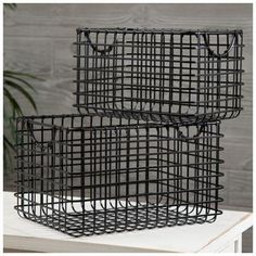 two black wire baskets sitting on top of a table