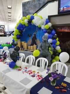 the table is set up with balloons and confetti for an animal themed party