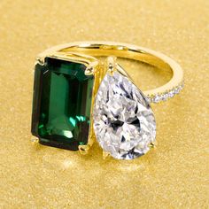 an emerald and diamond ring on a gold background