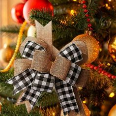 a christmas tree decorated with burluck and plaid bows, ornaments and baubles