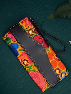 This beautiful wristlet is handcrafted by skilled Mexican artisans, featuring adoring patterns and vibrant colors. The compact design makes it perfect for carrying essential items with ease. Each wristlet is a unique piece of art, representing the rich cultural fashion of Mexico. Orange/Multicolor Bohemian Multicolor Wristlet For Gift, Bohemian Multicolor Wristlet As Gift, Bohemian Multicolor Embroidery Clutch, Rectangular Wallets With Wrist Strap As Gift, Rectangular Wallet With Wrist Strap As Gift, Rectangular Wallet With Wrist Strap For Gift, Artisan Multicolor Clutch As A Gift, Artisan Multicolor Rectangular Clutch, Handmade Multicolor Rectangular Clutch