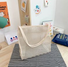 a beige bag sitting on top of a black and white striped rug